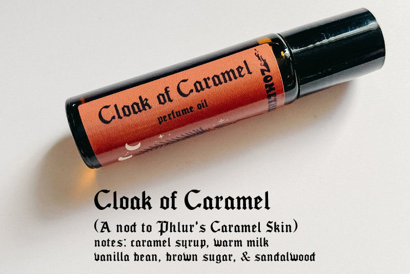 Perfume oil bottle labeled 'Cloak of Caramel' on a light gray background