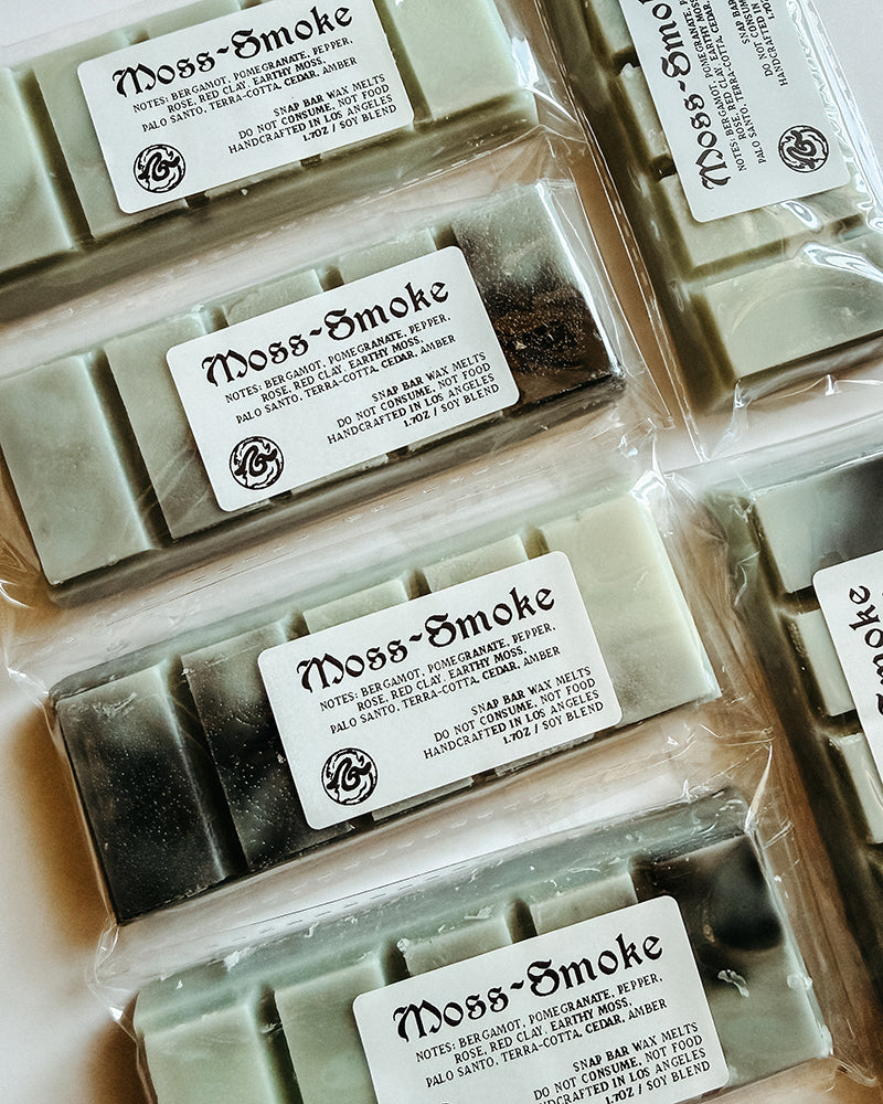 Moss-Smoke wax melt bars with labels in clear packaging.