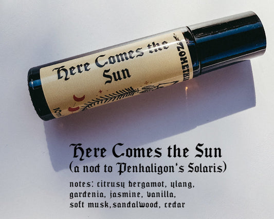 Roll-on perfume bottle labeled 'Here Comes the Sun' on a white background