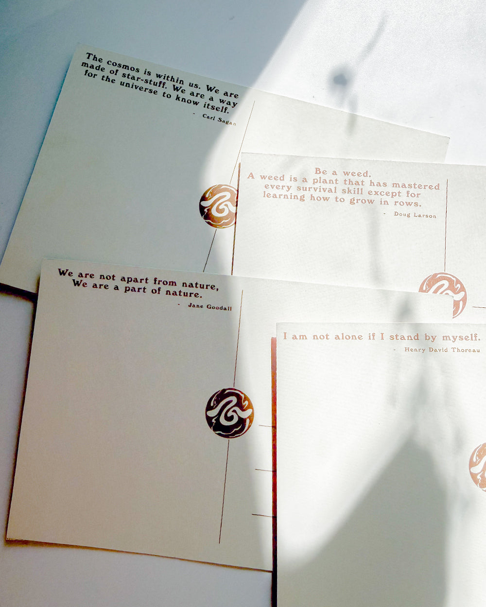 A set of cream-colored stationery cards featuring printed quotes by famous thinkers such as Jean Guizot, Tony Ross, and Steve Harvey Thorne, decorated with circular metallic foil seals.