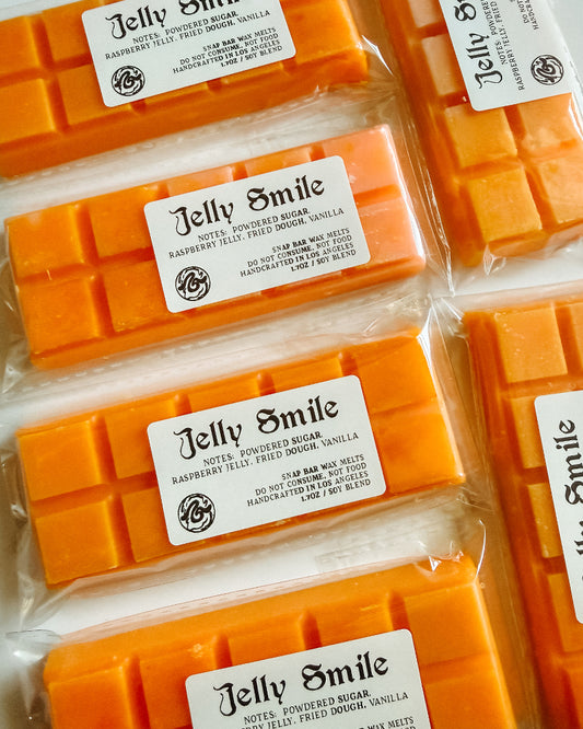 Orange wax bars with 'Jelly Smile' labels in clear packaging.