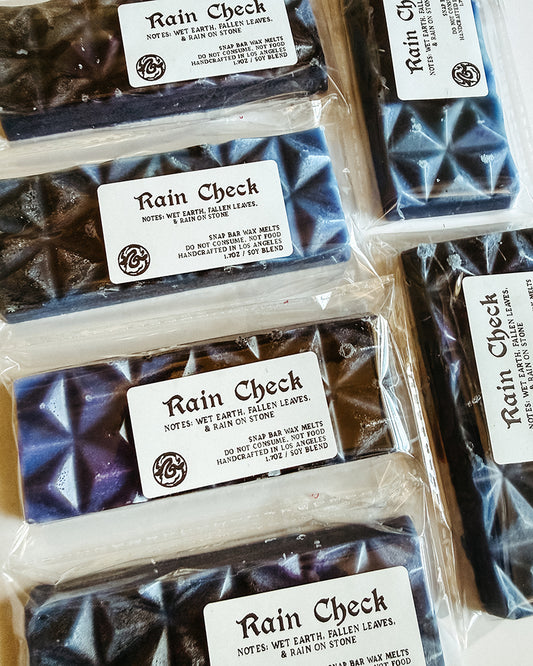 black and blue wax bars with clear labeling Rain Check on it. 
