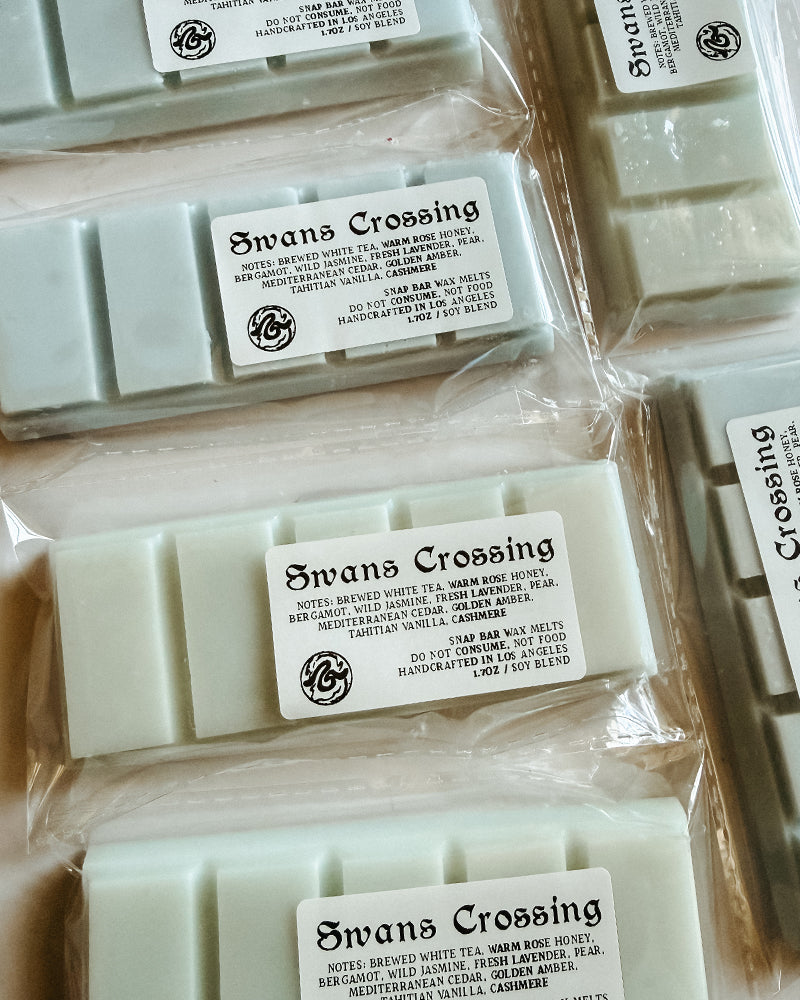 Multiple bars of Swans Crossing wax melts in packaging with visible branding.