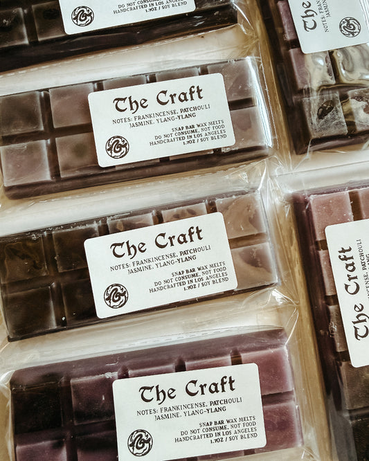 Wax Melt bars labeled 'The Craft' in clear packaging. Coloring of bar is dark gray and purple.
